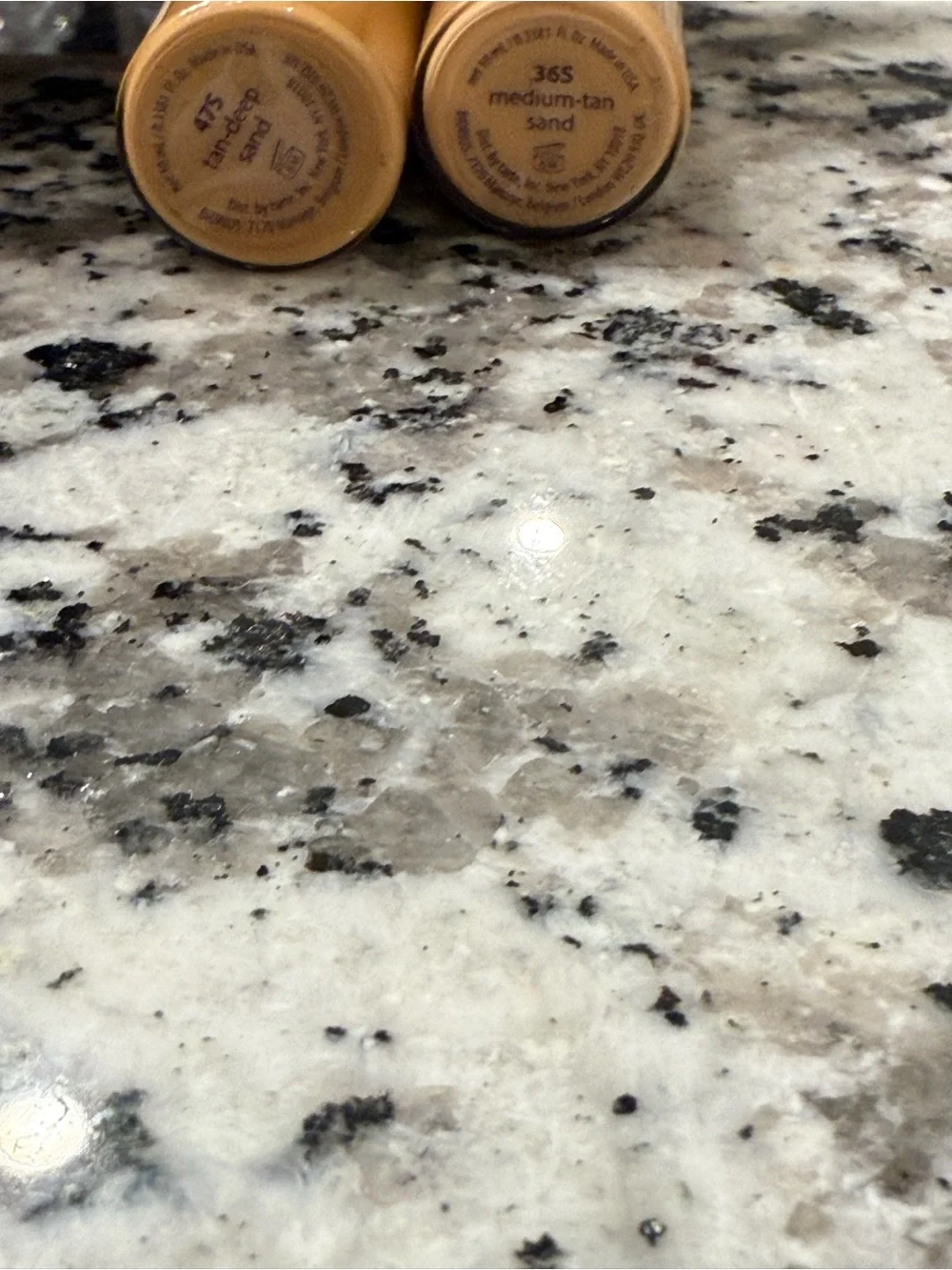 tarte concealer sticks with purple-and-gold patterned bases